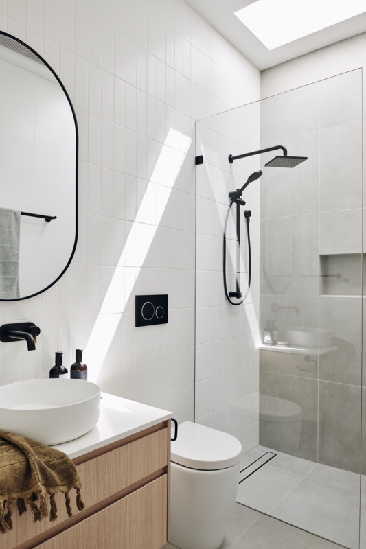 Minimalist Walk-In Shower Design: Vertical White Tiles & Skylight