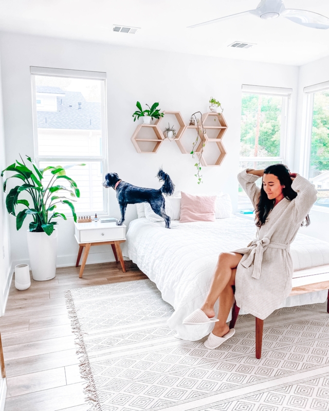 Minimalist White Bedroom with Honeycomb Wall Shelves and Geometric Rug