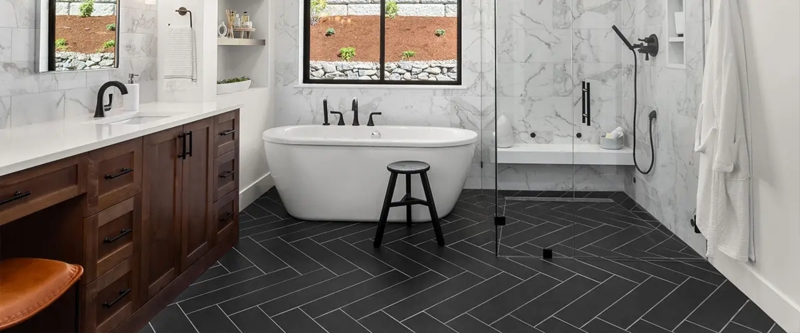 Modern Bathroom With Dark Herringbone Floor And Marble Wall Tiles