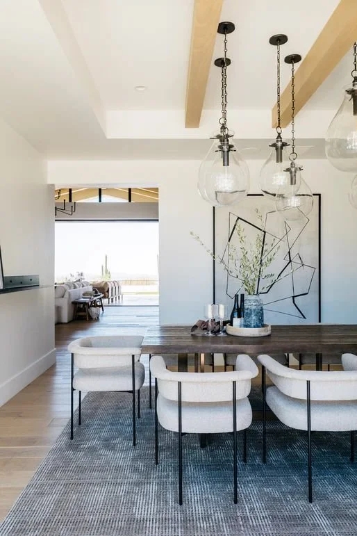 Modern Dining Room featuring Blue Textured Rug and Glass Pendants