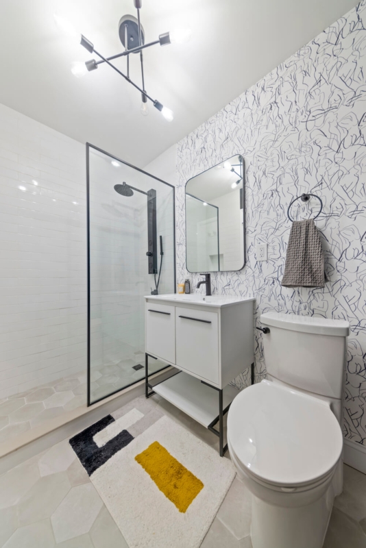 Modern Doorless Walk-In Shower: Line Art Wallpaper & Black Fixtures