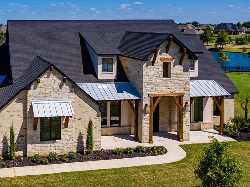 Modern Farmhouse Exterior: Stone, Wood, and Metal Awnings