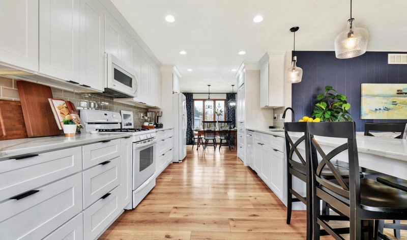 Modern Galley Kitchen with Light Wood Floors and Navy Accent Wall