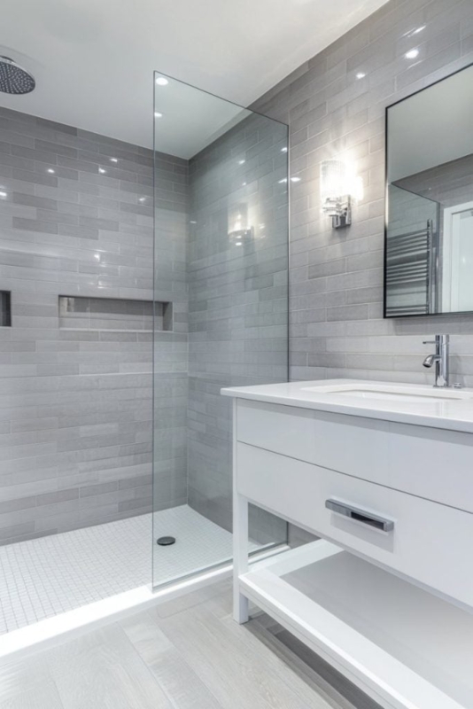 Modern Gray Bathroom using Linear Subway Tile and Frameless Glass