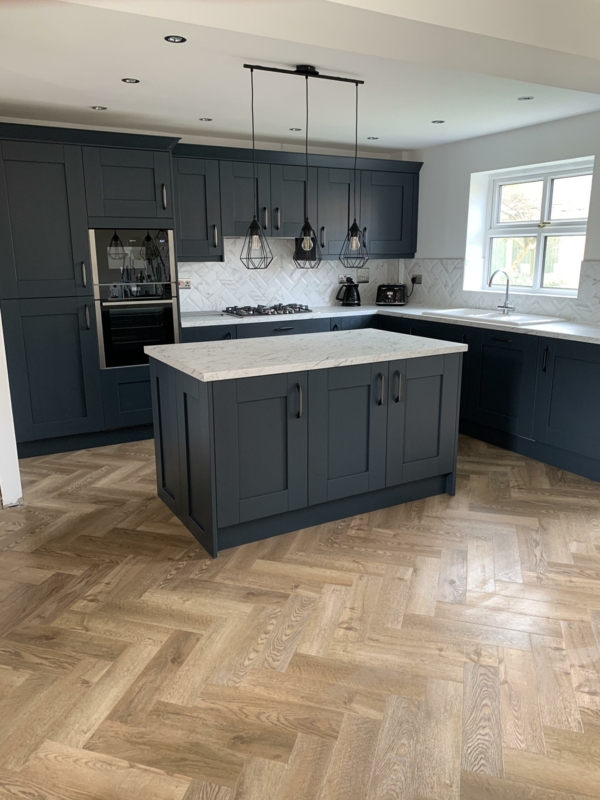 Modern Kitchen with Herringbone Wood Floor and Navy Shaker Cabinets