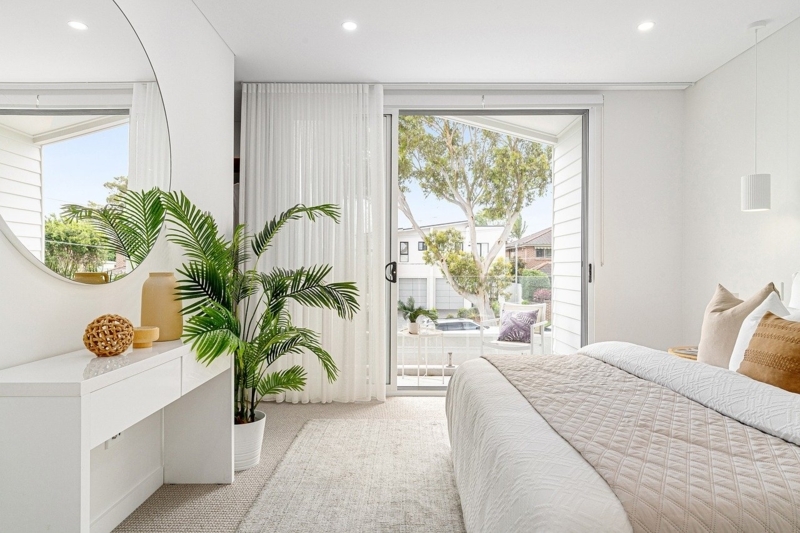 Modern Minimalist Bedroom with Sliding Balcony Door and Lush Palm Plant