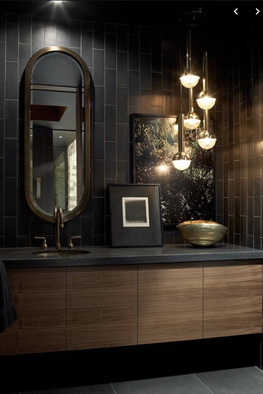 Modern Wood Vanity with Dark Vertical Tiles and Oval Brass Mirror