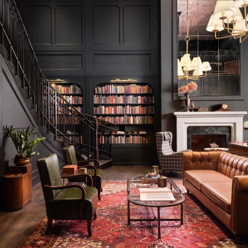 Moody Dark Library Design: Arched Recessed Bookshelves & Chesterfield
