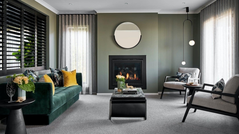Moody Green Wall Living Room: Dark Velvet Sofa & Minimalist Fireplace