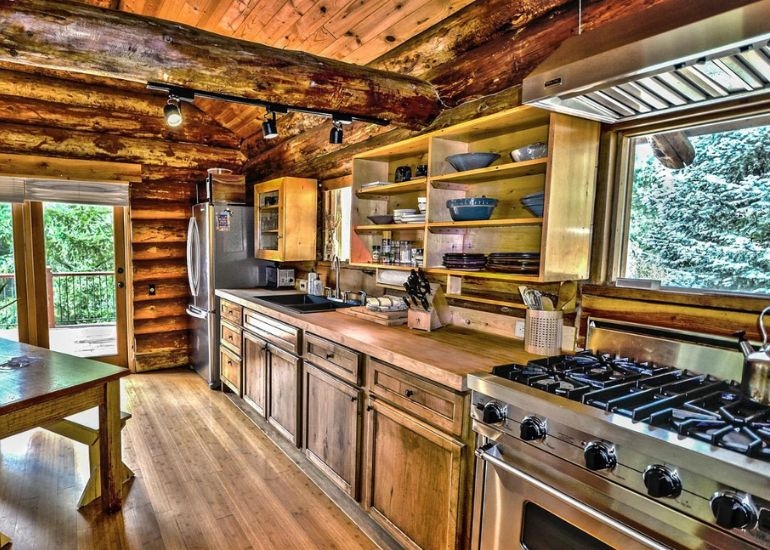 Mountain Log Cabin Kitchen with Stainless Steel Range and Open Shelving