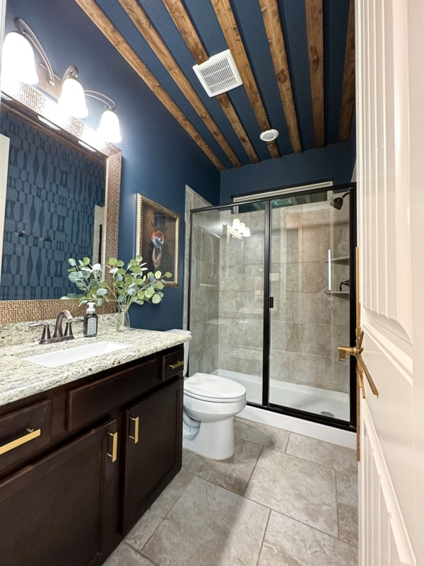 Navy Blue Bathroom Design with Exposed Wood Beams and Gold Hardware