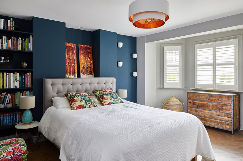 Navy Blue Bedroom Accent Wall with Tufted Headboard and Shelving.