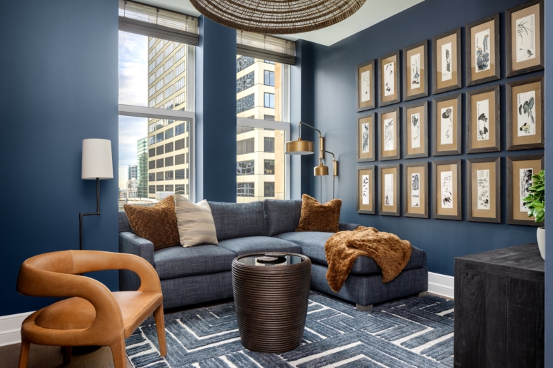 Navy Gallery Wall Living Room: Botanical Grid Art and Curved Tan Chair