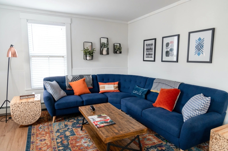 Navy Tufted Sectional with Burnt Orange Accents and Copper Floor Lamp