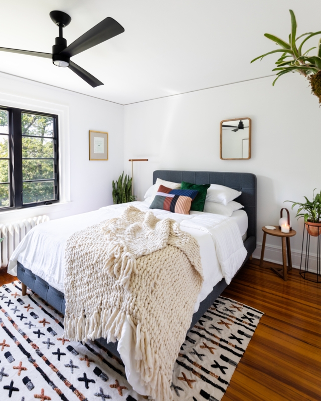 Navy Upholstered Bed with Chunky Knit Throw & Geometric Rug