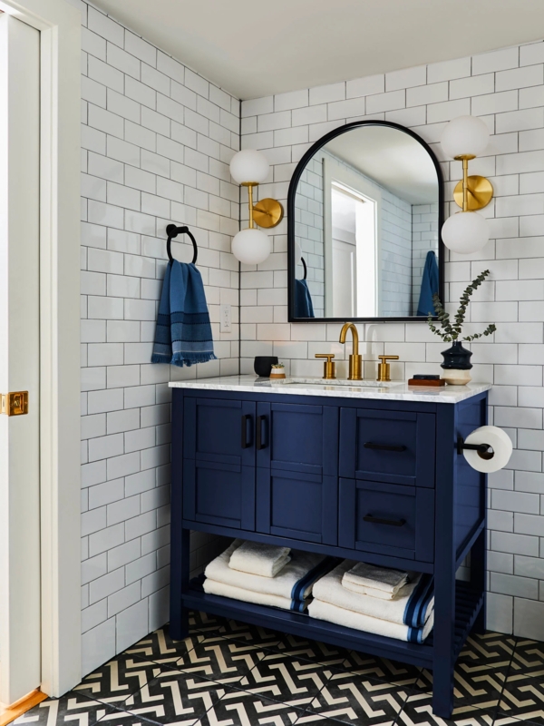 Navy Vanity Bathroom with Arched Mirror and Brass Faucet and Hardware