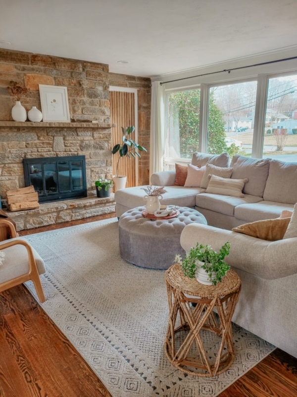 Neutral Living Room with Stone Fireplace Wall and Tufted Ottoman
