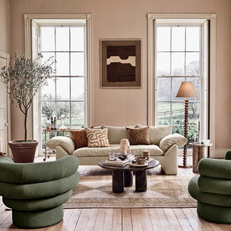 Neutral Sofa with Sculptural Green Chairs and Large Sash Windows