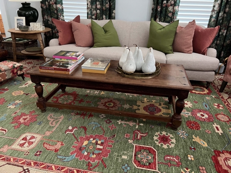 Olive Green Area Rug with a Rustic Turned Leg Coffee Table.