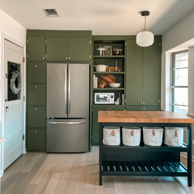 Olive Green Kitchen Cabinets with Black Island and Basket Storage.