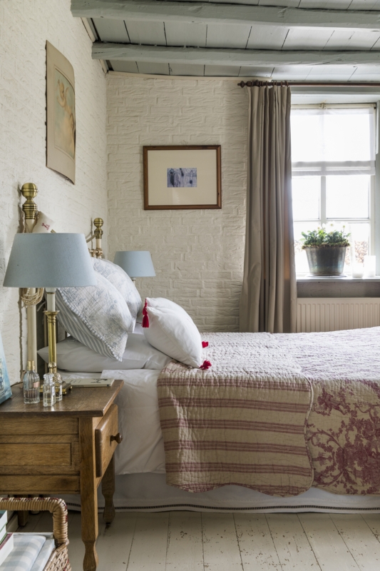 Painted Brick Wall with Exposed Ceiling Beams and Layered Bedding