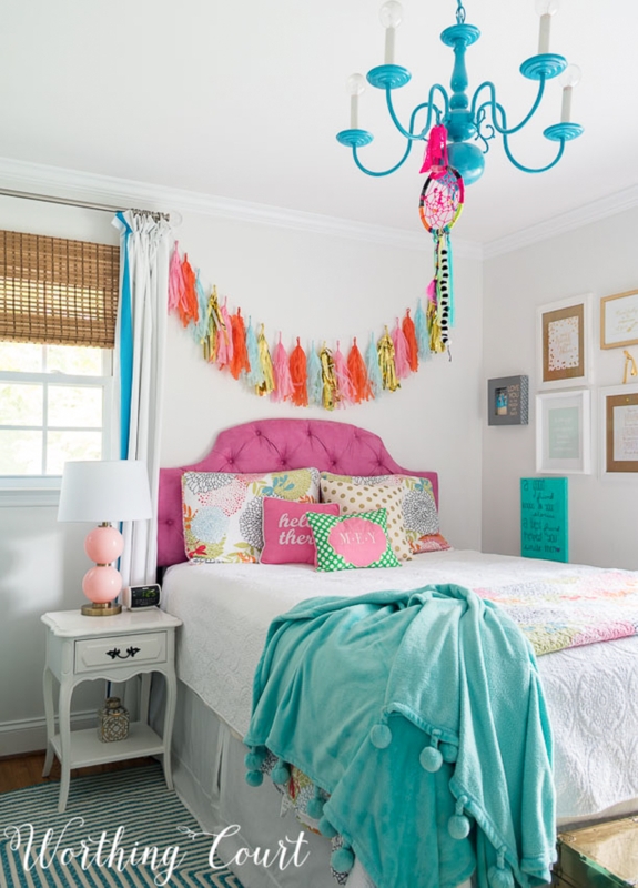 Pink Tufted Headboard and Blue Chandelier in Vibrant Bedroom