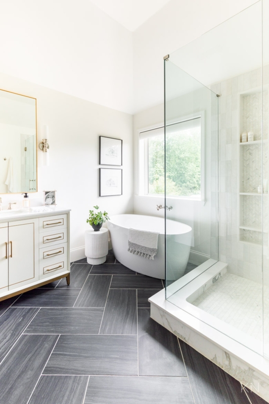 Primary Bathroom Suite with Herringbone Floor and Freestanding Oval Tub