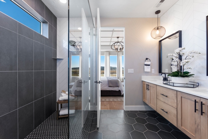Primary Suite Bathroom With Charcoal Gray Walk-In Shower And Wood Vanity