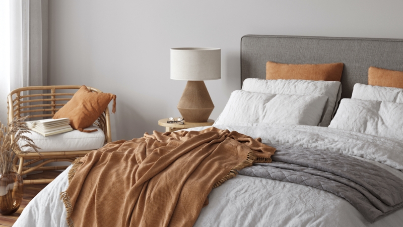 Rattan Accent Chair with Terracotta Accents in a Boho Chic Bedroom