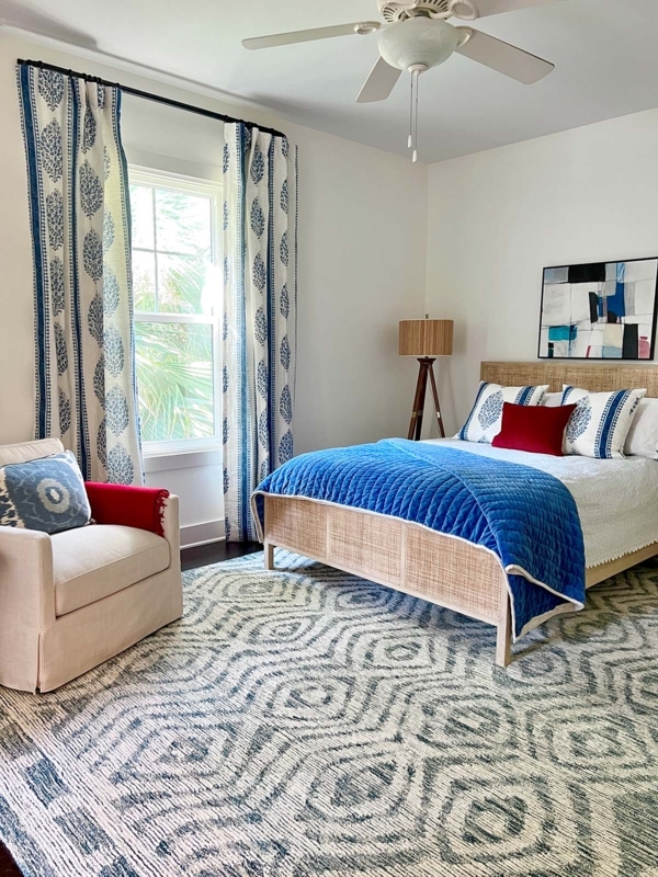 Rattan Bed Frame with Geometric Blue Rug and Red Accents