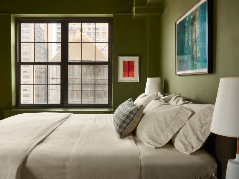 Refined Bed against Deep Olive Green Walls with City View