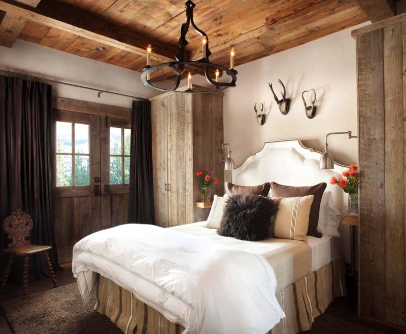 Rustic Bed with Striped Bed Skirt and Antler Wall Art above Headboard