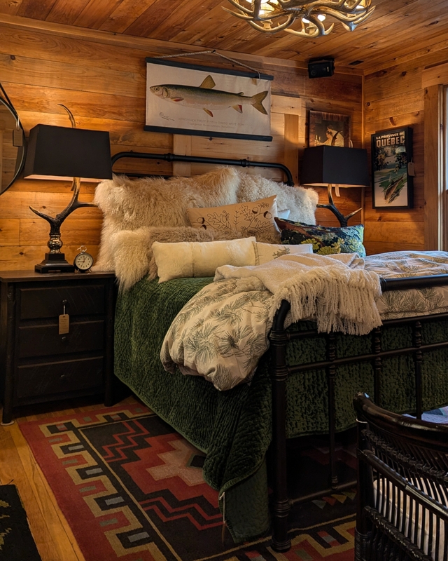 Rustic Bedroom Decor With Antler Lamps And Layered Wood Paneled Walls