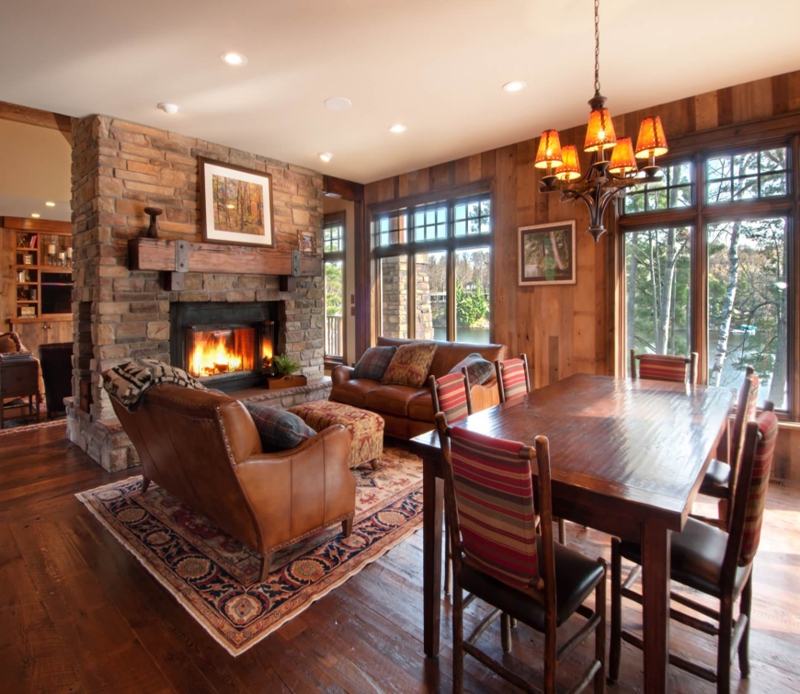 Rustic Cabin Dining Room with Wood Paneling and Stone Fireplace