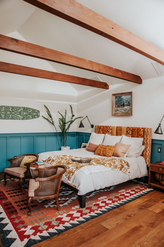 Rustic Coastal Bedroom with Teal Wainscoting and Patterned Headboard