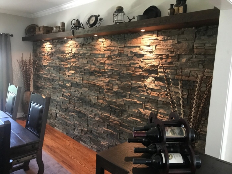 Rustic Dining Room featuring Stone Accent Wall with Under Shelf Lighting