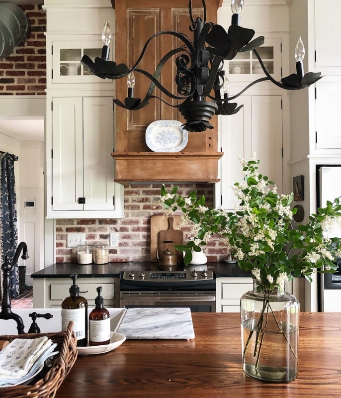 Rustic Kitchen with Exposed Brick Backsplash and Wood Range Hood