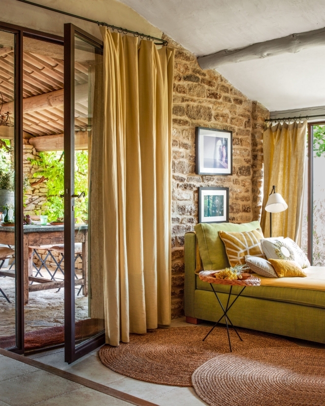 Rustic Sunroom: Mustard Floor-to-Ceiling Curtains against Stone Wall