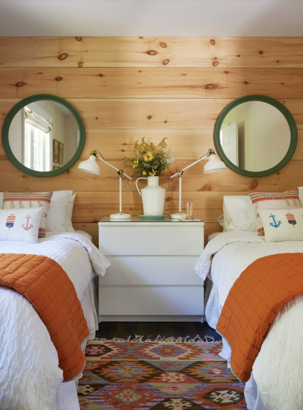 Rustic Twin Bedroom with Horizontal Wood Paneling and Burnt Orange Throws