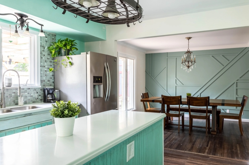 Sage Green Geometric Accent Wall with Teal Kitchen Cabinetry