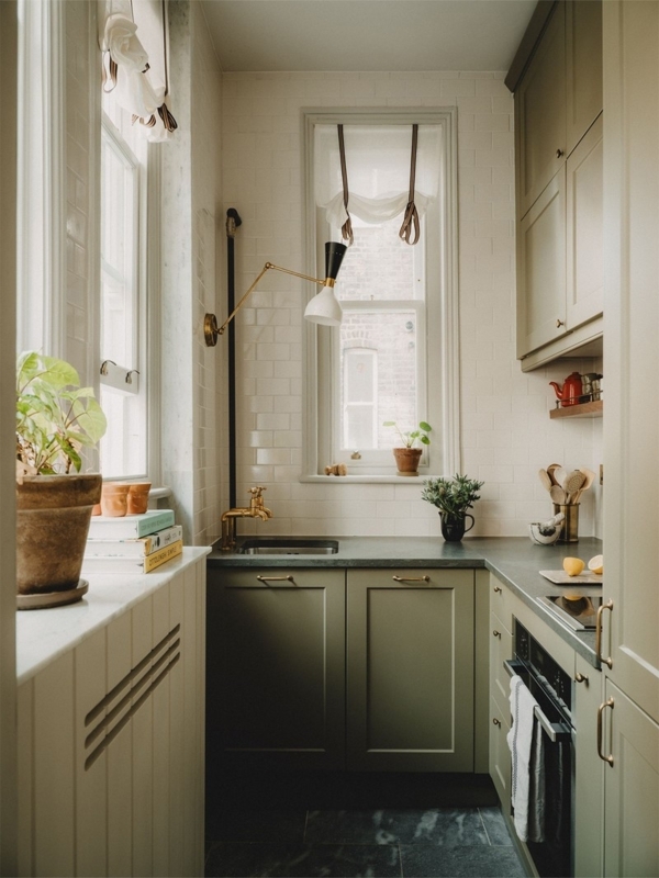 Sage Green Kitchen Cabinet Design with Brass Swing Arm Lamp
