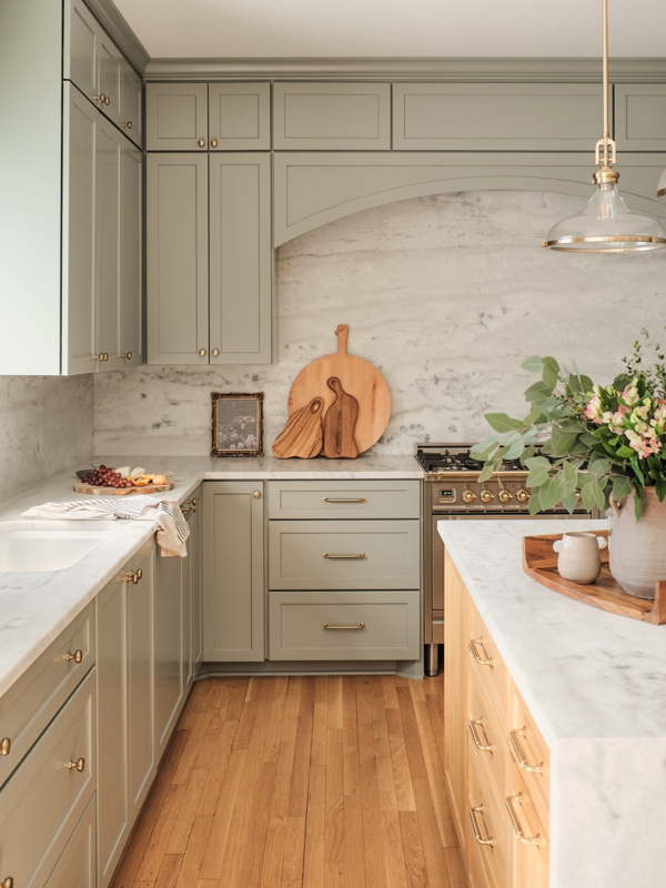 Sage Green Kitchen Cabinetry with Marble Slab Backsplash & Arched Hood