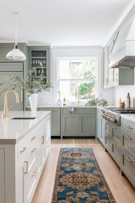 Sage Green Kitchen Cabinets with White Island and Ornate Runner Rug.