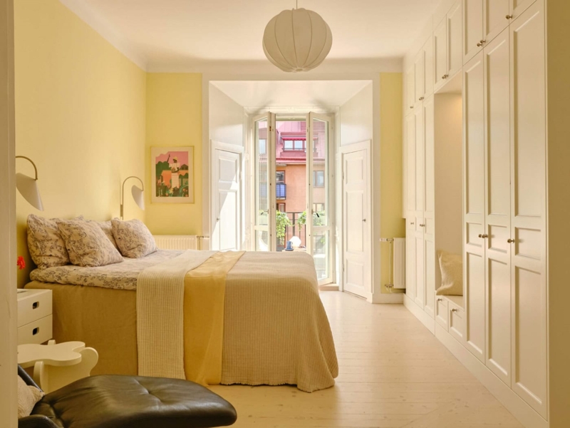 Scandinavian Bedroom with Pale Yellow Walls and Balcony Doors