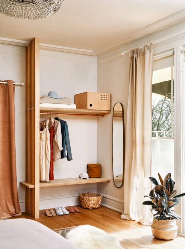 Scandinavian Closet System With Slatted Wood Partition and Copper Rod
