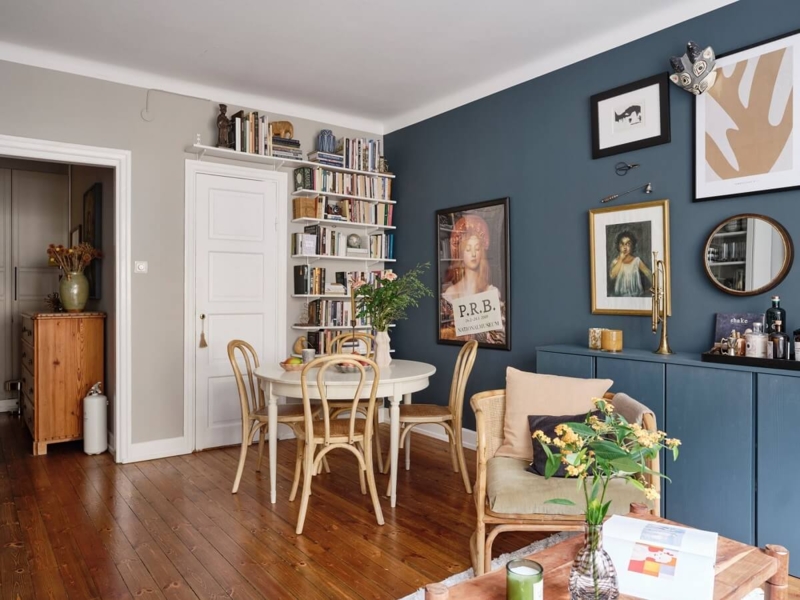 Scandinavian Dining Nook with Dark Blue Wall & Vertical Library