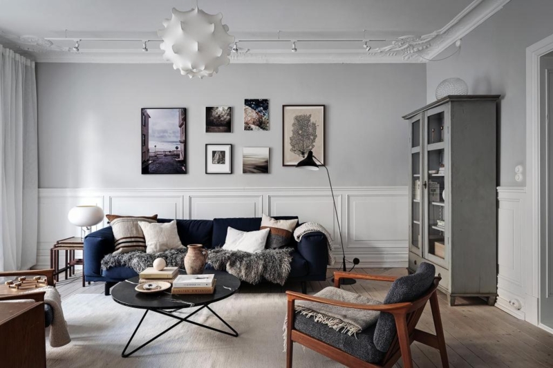 Scandinavian Modern Navy Sofa with White Wainscoting and Gallery Wall
