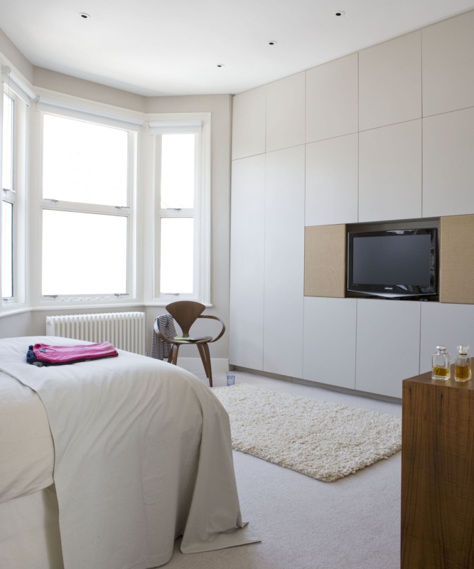 Seamless Storage Wall with Integrated TV and Sculptural Accent Chair