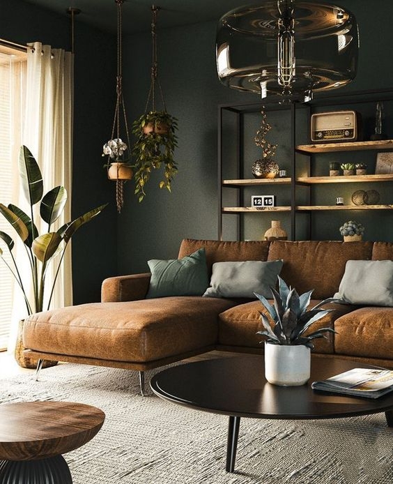 Sectional Sofa Cognac Leather Like against Dark Green Walls and Plants.