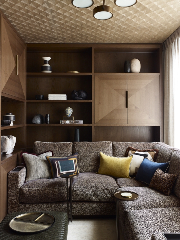 Sectional Sofa Speckled Upholstery with Built-in Shelving and Decor.